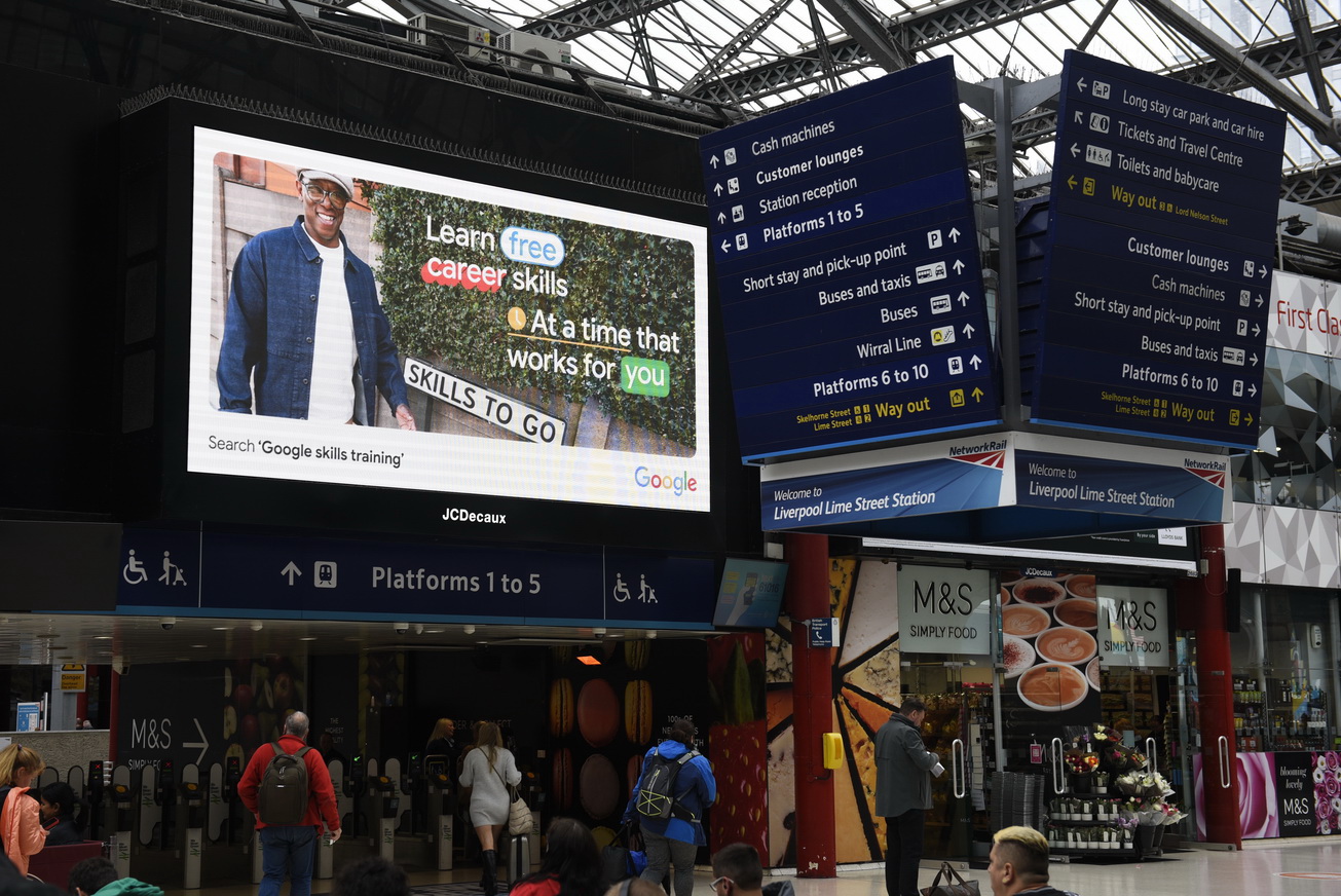 digital advertising screens at UK mainline train station photographs