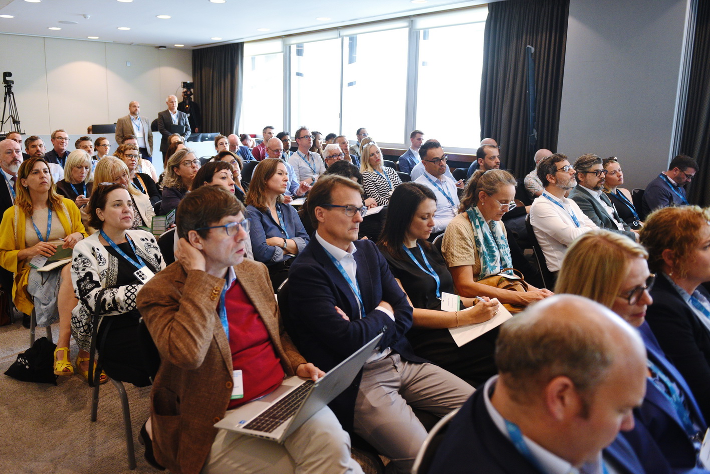 Crowd of seated delegates listening to a presentation