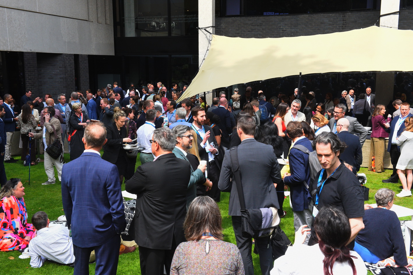 Wide angle photo of large crowd of delegates at a garden party